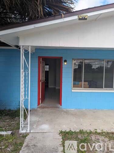 A blue house with a red door and a window.