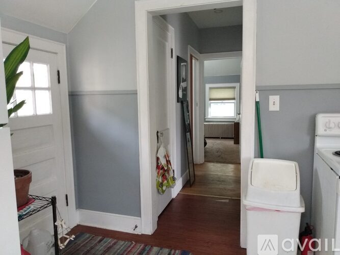 A room with a white door and a white washing machine.