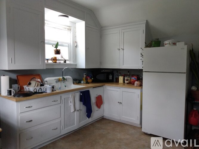 A kitchen with white cabinets and a window above the stove.
