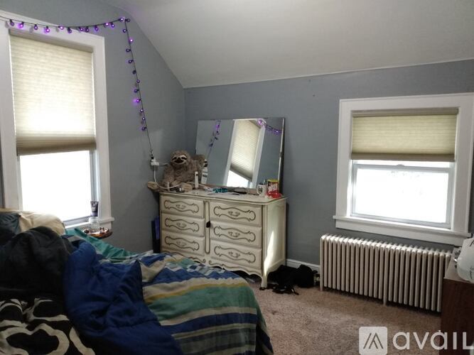 A bedroom with a bed, dresser, and window.