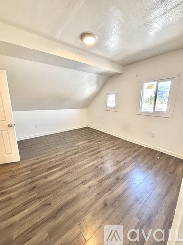 A room with wooden flooring and a window.