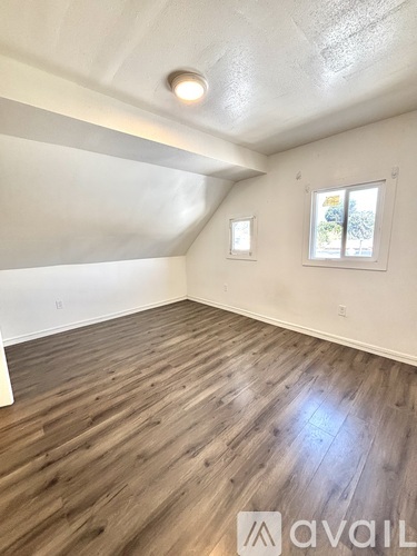 A room with wooden flooring and a window.