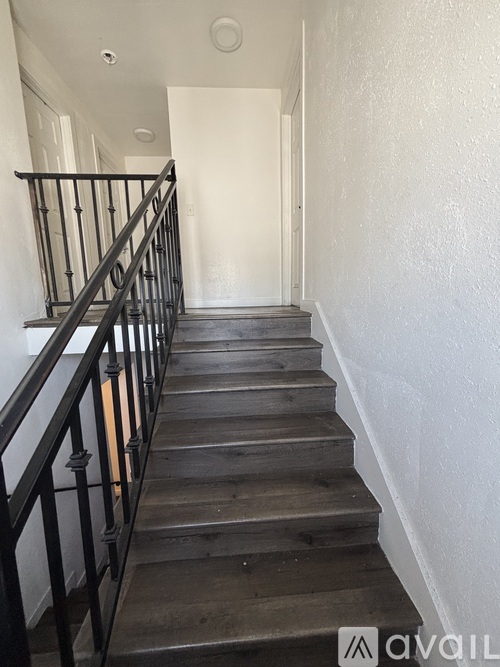 A staircase with wooden steps and black railings.