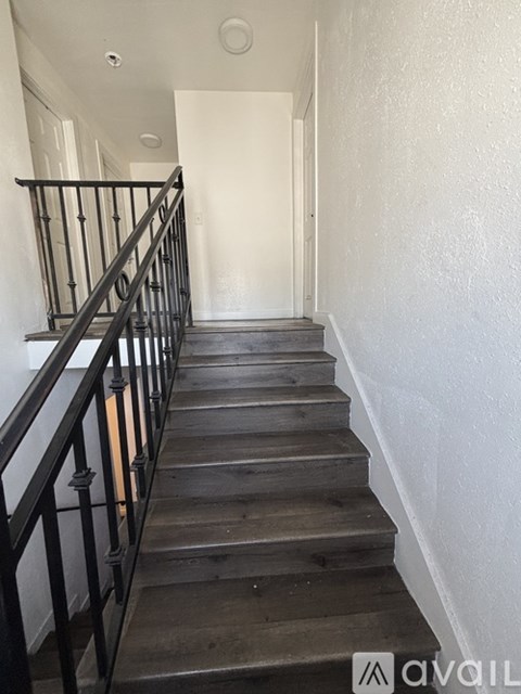 A staircase with wooden steps and black railings.