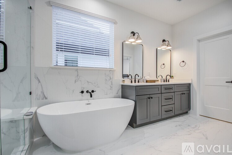 A bathroom with a white tub and marble countertops.