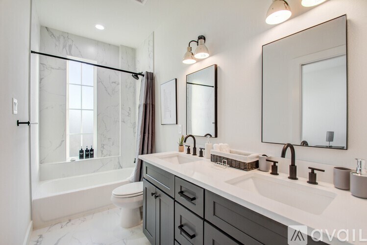 A bathroom with a marble floor and a large mirror above the sink.