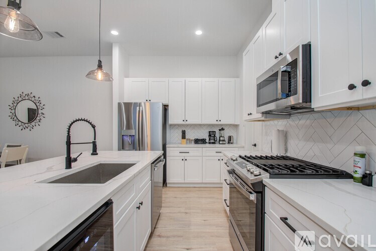 A modern kitchen with white cabinets and a black stove top.