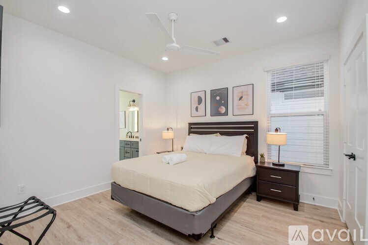 A bedroom with a bed, nightstand, and two lamps.