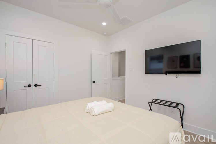 A bedroom with a bed, a chair, and a painting on the wall.