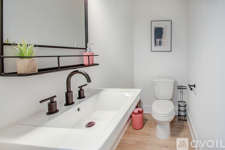 A bathroom with a white sink and a toilet.