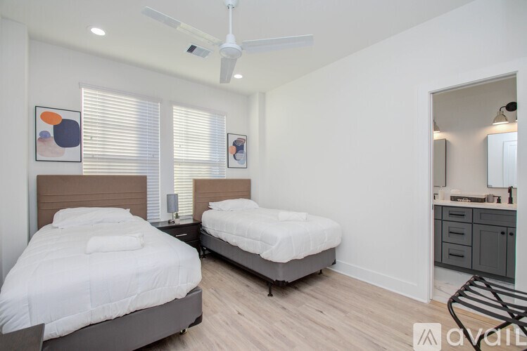 A bedroom with two beds and a ceiling fan.