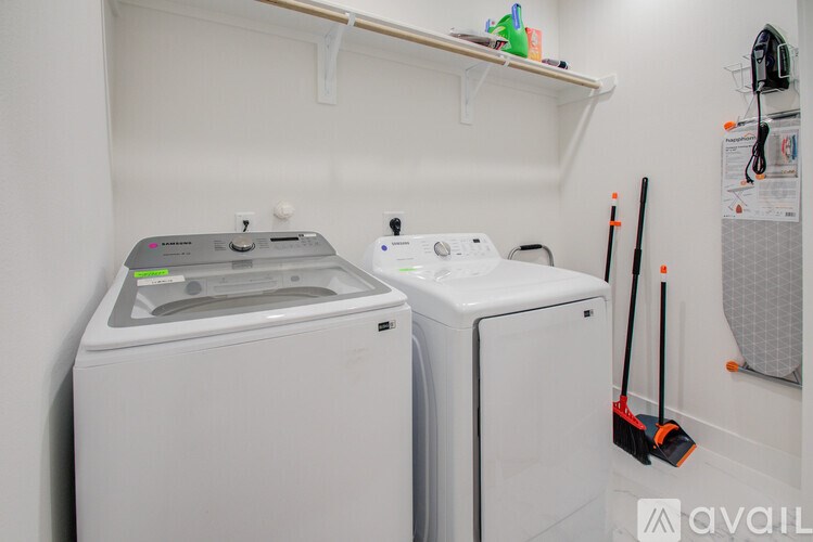 A white dryer and washer are in a small laundry room.