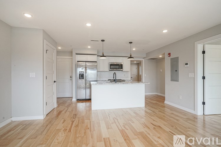 A kitchen with white cabinets and a wooden floor.