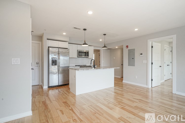 A kitchen with a white island and wooden floors.