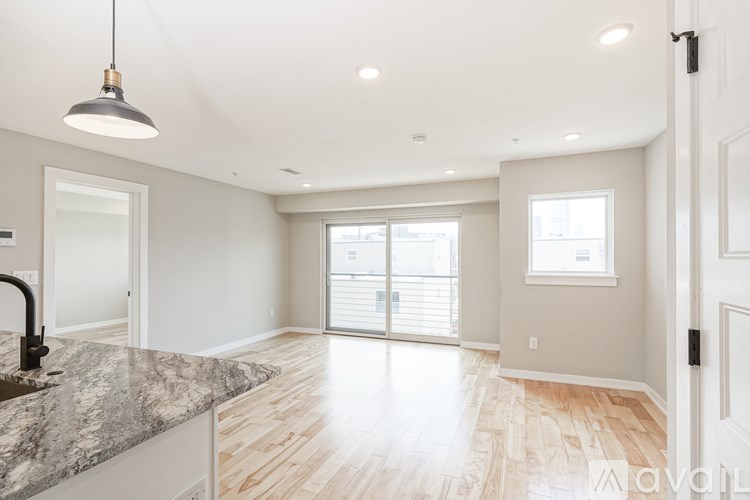 A kitchen with a marble countertop and wooden flooring.