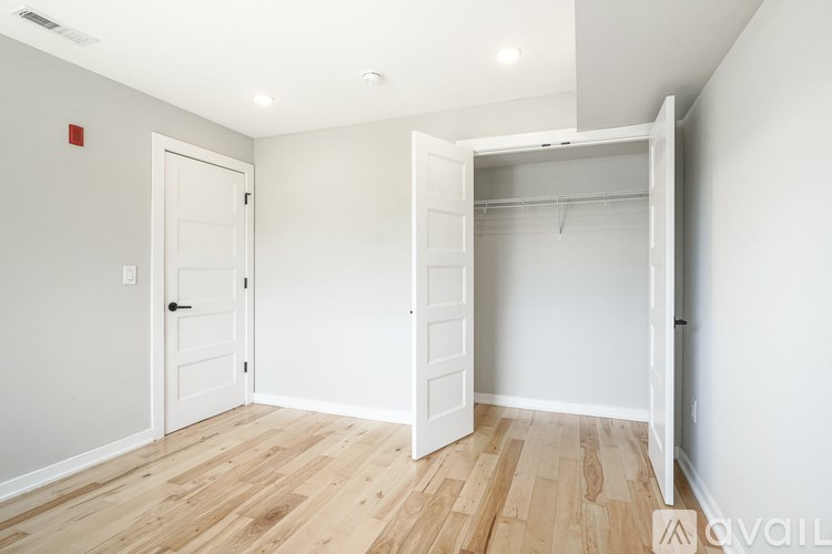 A room with a white door and a white closet with a white shelf.