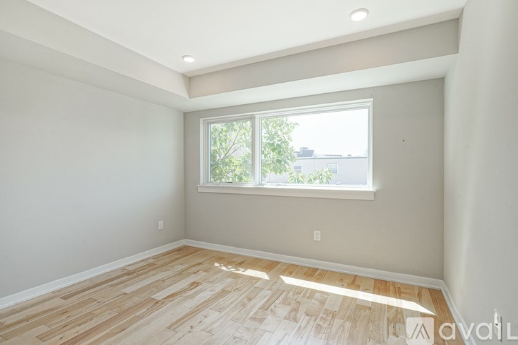 A room with a window and wooden flooring.