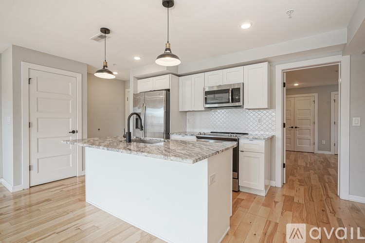A kitchen with a marble countertop and white cabinets.