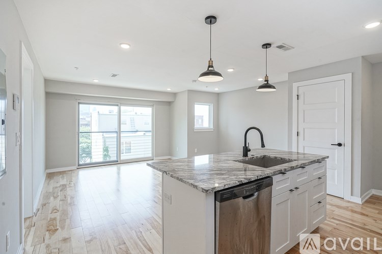A kitchen with a marble countertop and a dishwasher.
