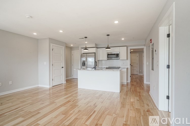 A kitchen with white cabinets and a wooden floor.