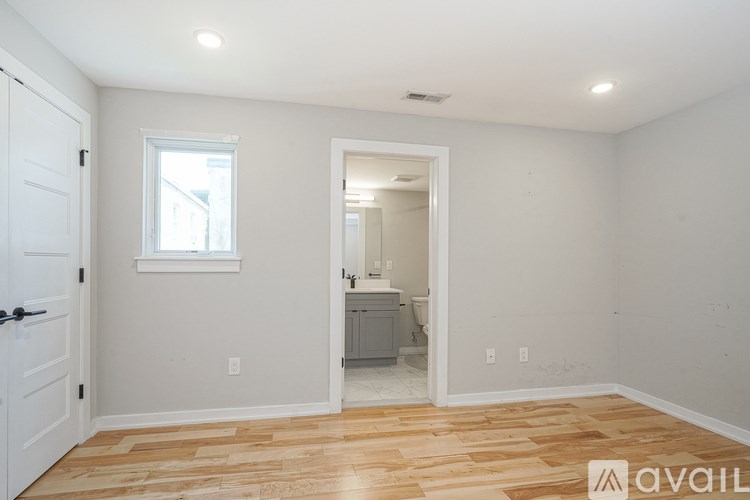 A room with a wooden floor and a white door.