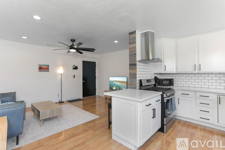 A kitchen with white cabinets and a black door.