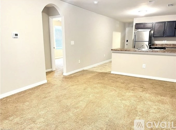 A kitchen area with a refrigerator, microwave, and cabinets.