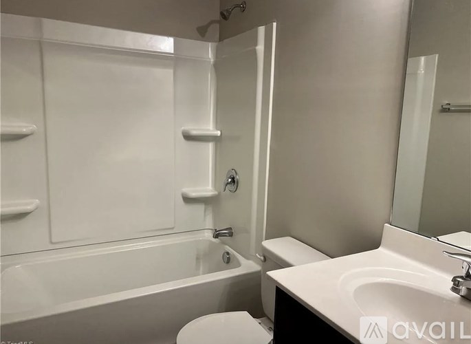 A white bathroom with a tub, toilet, and sink.