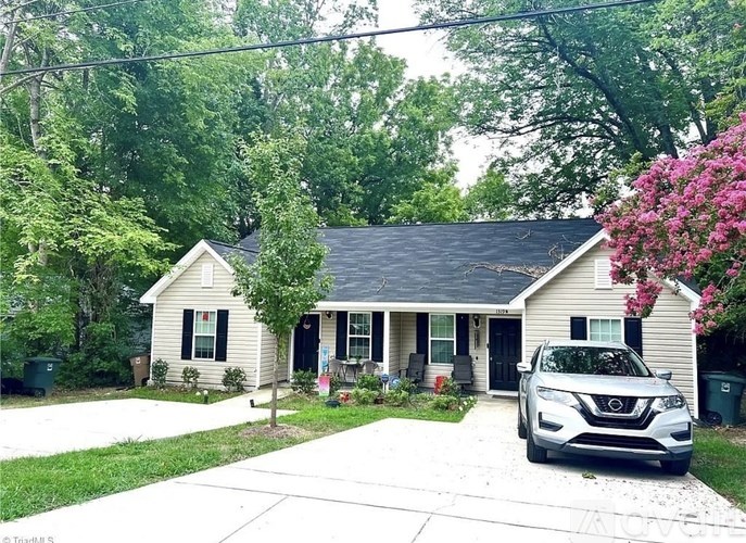 A house with a car parked in front of it.