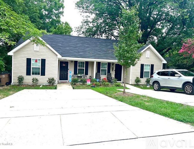 A house with a white car parked in front.