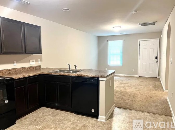A kitchen with black cabinets and a granite countertop.