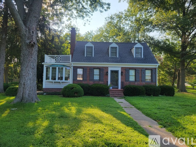 A house with a red brick chimney and a white porch.