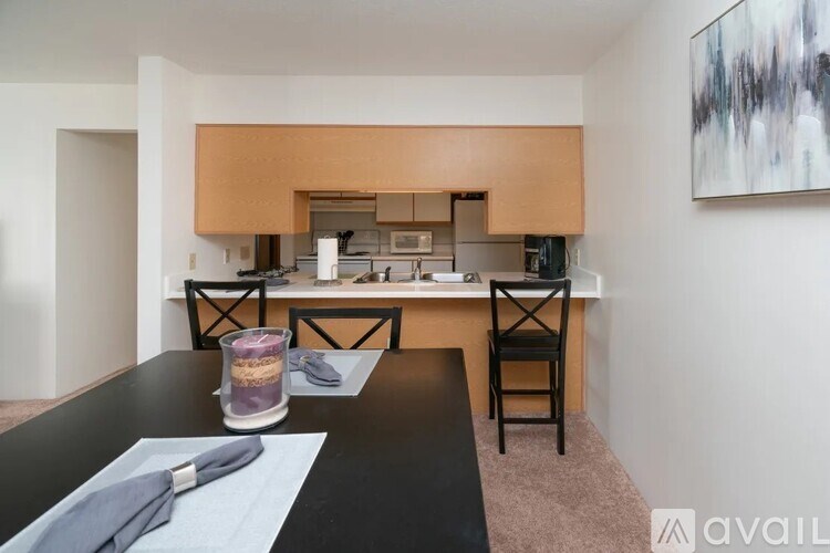 A modern kitchen with a dining table set for two.