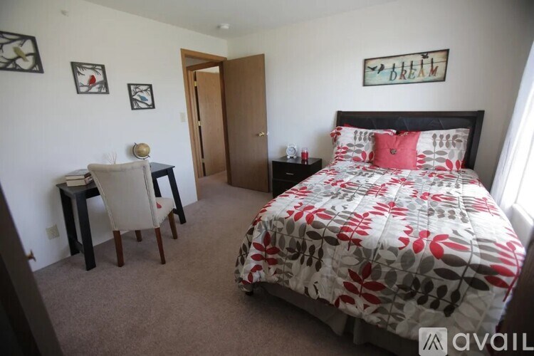 A bedroom with a bed, desk, and chair.