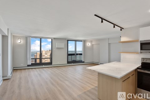 A spacious kitchen with a large island and wooden flooring.