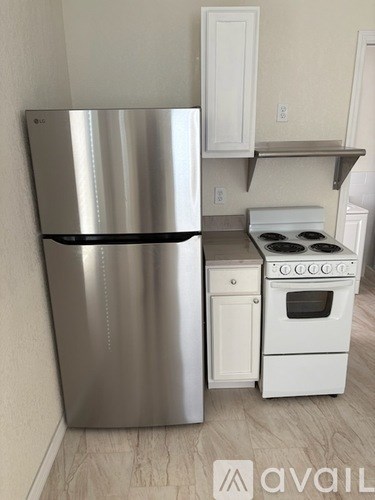 A stainless steel refrigerator and white oven in a kitchen.