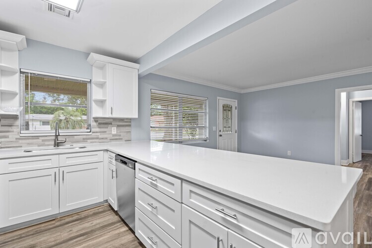 A kitchen with white cabinets and a white countertop.
