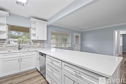 A kitchen with white cabinets and a white countertop.