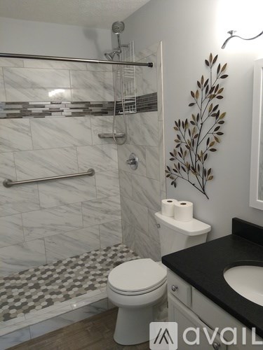 A bathroom with a toilet, sink, and shower.