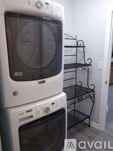 A white Maytag oven is stacked on top of a black oven.