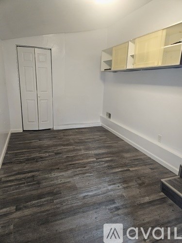 A room with wooden flooring and a white door.