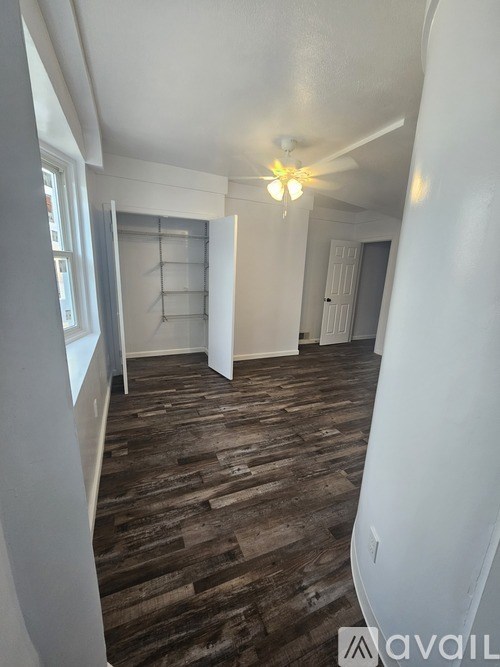 A room with wooden flooring and a white wall.
