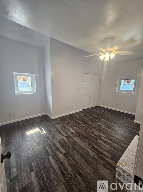 A room with wooden flooring and a ceiling fan.