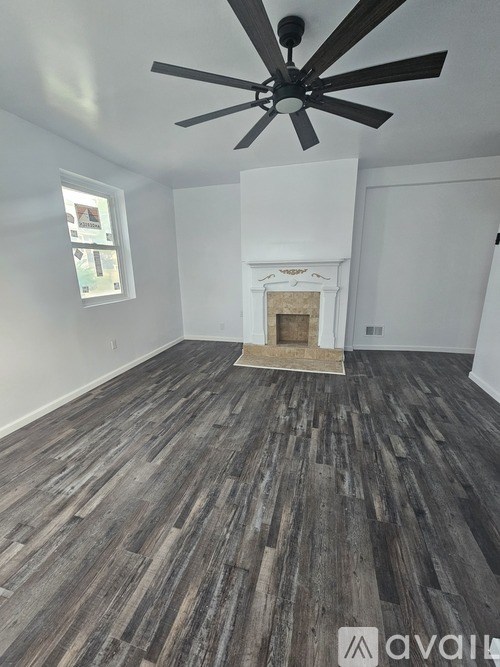 A room with a fireplace and wood flooring.