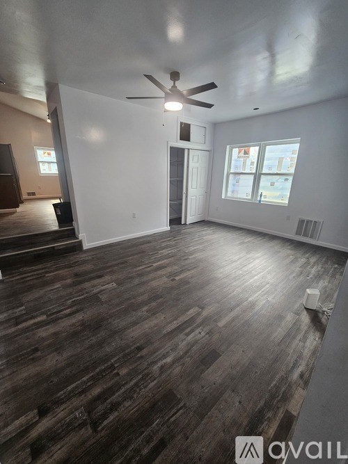 A room with wooden floors and a ceiling fan.