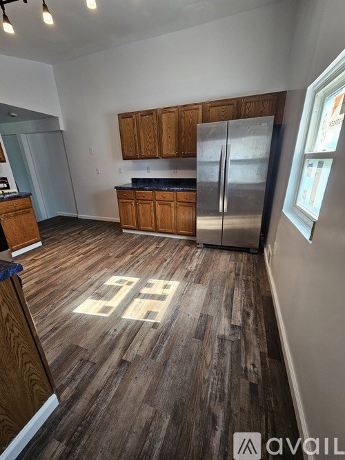 A kitchen with wooden cabinets and a refrigerator.