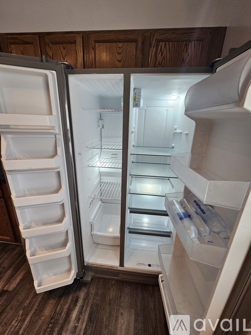 A white refrigerator with its door open in a kitchen.