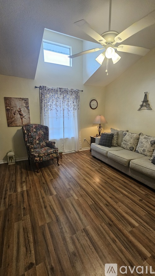 A room with wooden floors and a ceiling fan.
