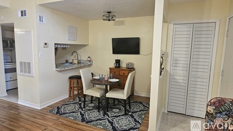 A dining area with a table and chairs in a room.