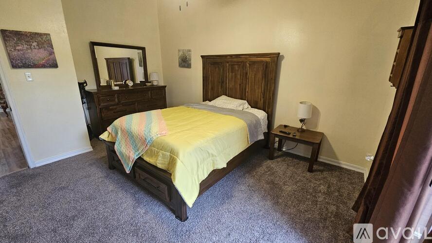 A bedroom with a bed, nightstand, and lamp.